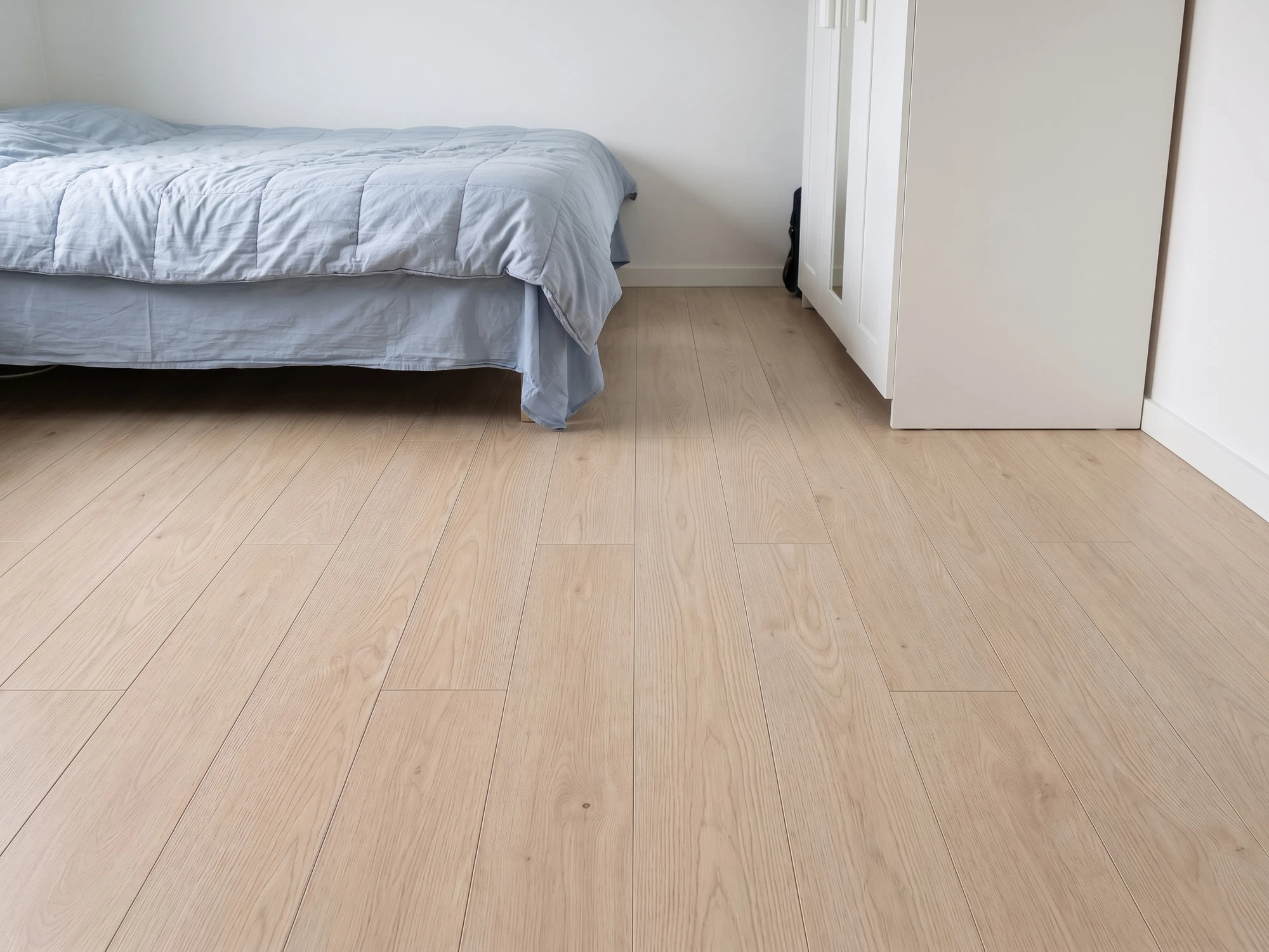 Schlafzimmer mit hellem Laminat in Sandeiche